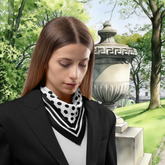 Woman wearing a black and white polka dot scarf in a park setting