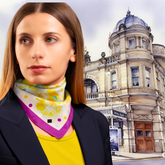 Woman wearing a colourful scarf with a historic building in the background, Buxton Opera House