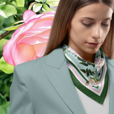 Woman wearing a floral rose silk twill scarf with a pink rose in the background