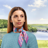 Woman wearing a colourful patterned silk scarf scarf with a scenic background of a lake and bridge in the Peaks.