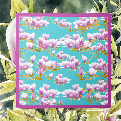 Floral pattern Silk Scarf with pink flowers on a blue background, framed by green leaves.