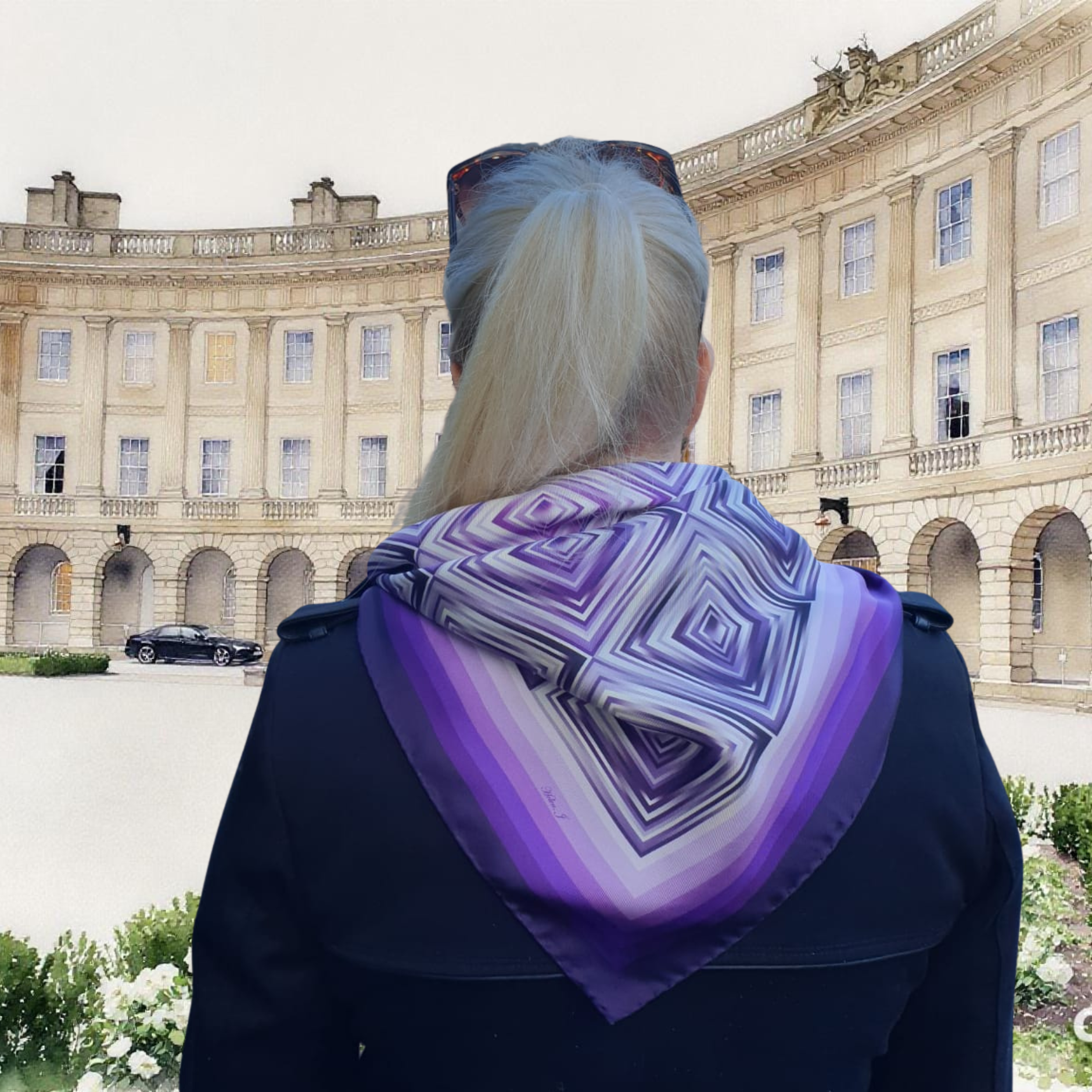 Person wearing a purple and white patterned scarf in front of a large building