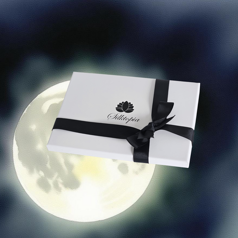 White gift box with black ribbon and 'Silltopia' logo against a moonlit sky