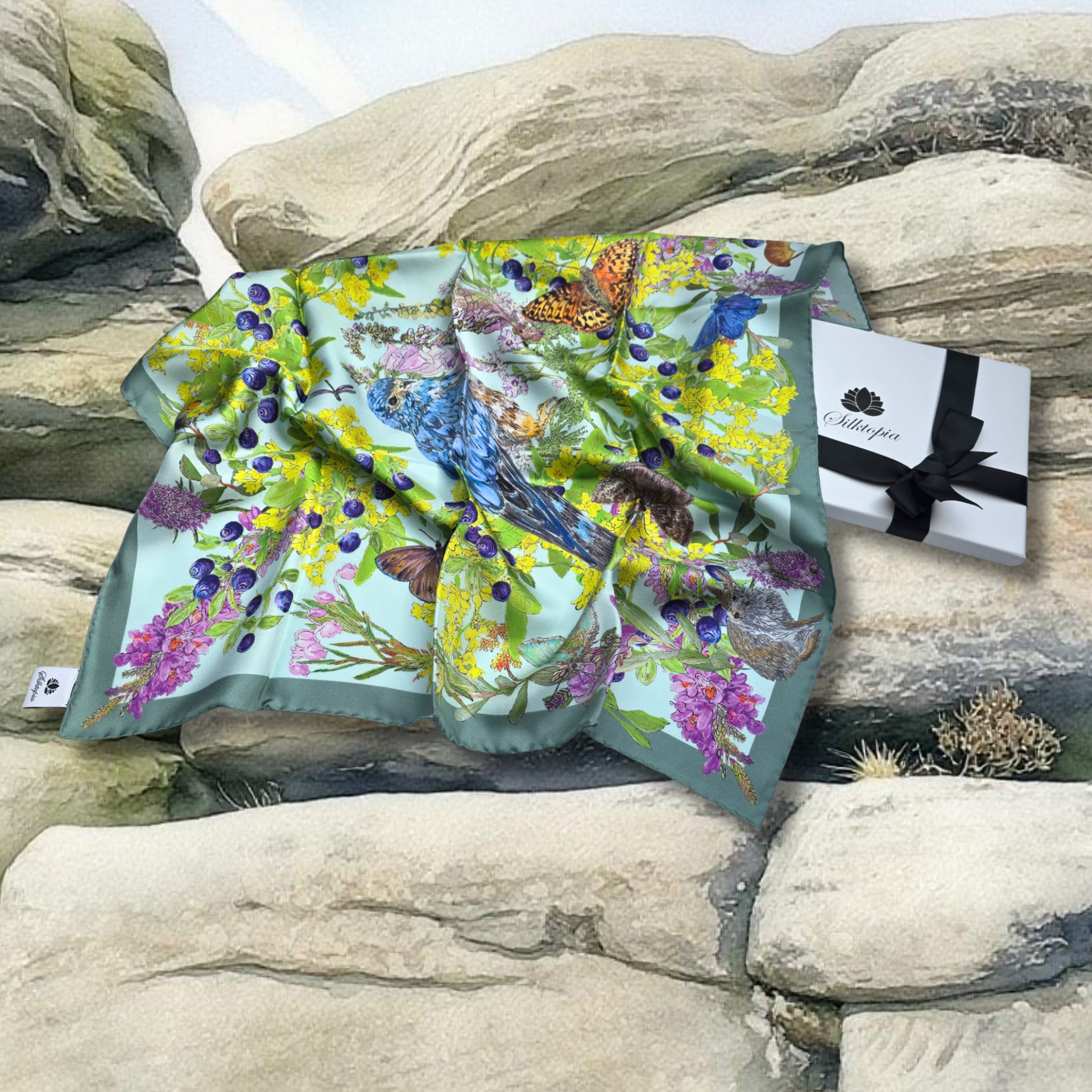 Butterfly-themed scarf on rocks with a Silktopia Gift Box.