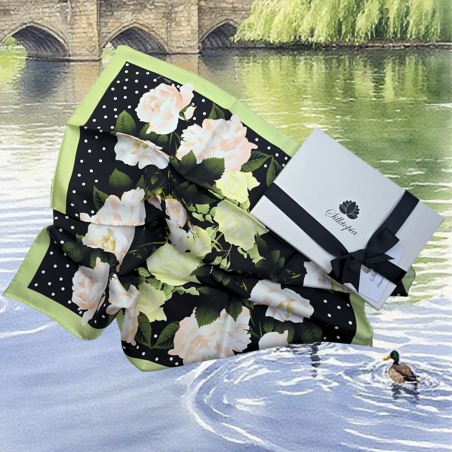 Floral-patterned product with a box on a scenic background with water and a bridge.