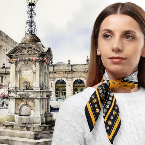 Woman wearing a patterned scarf in front of a fountain and building